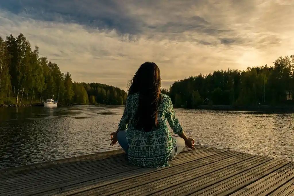 Femme assises devant un étang : Sophrologie et eft, la combinaison gagnante pour le client